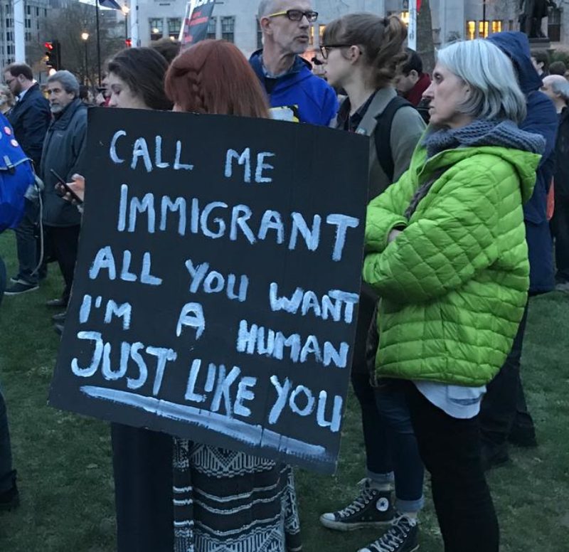A placard that reads "Call me immigrant all you want, I